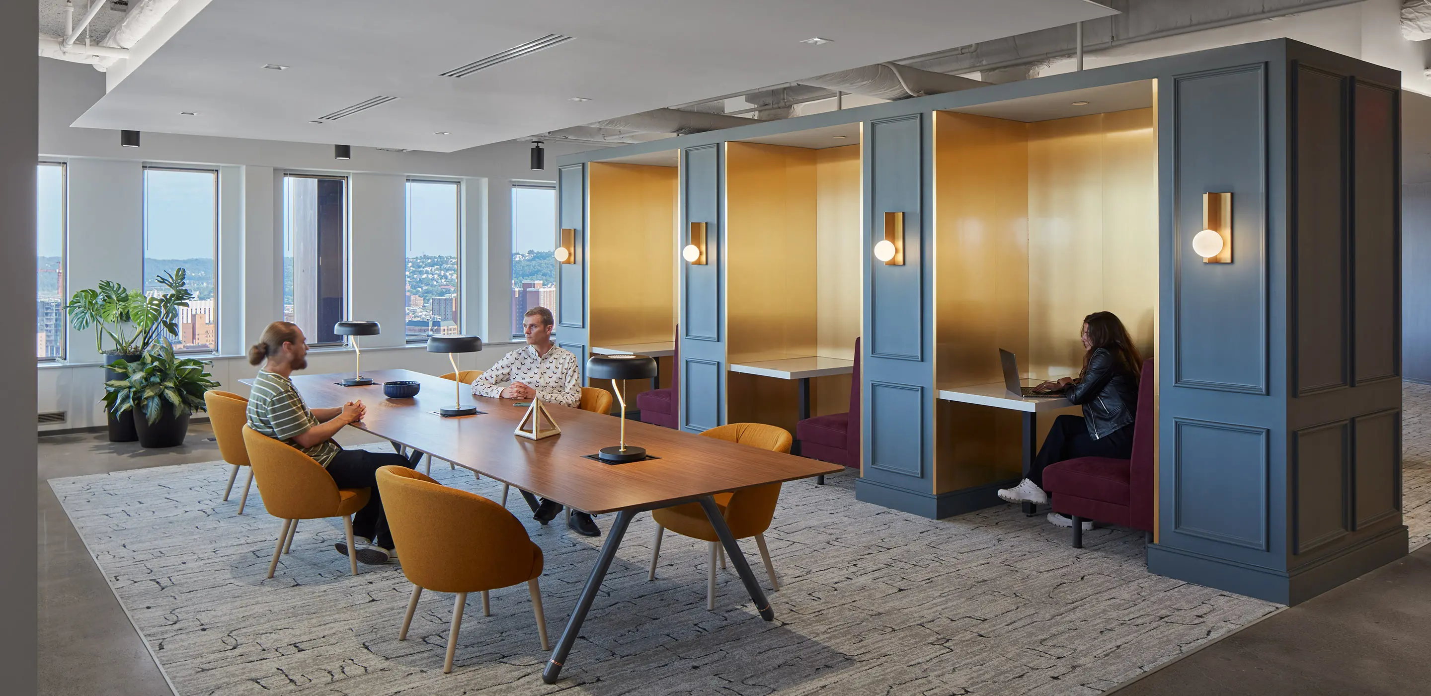 Two people sitting at a large wooden conference table in an elegant office interior.