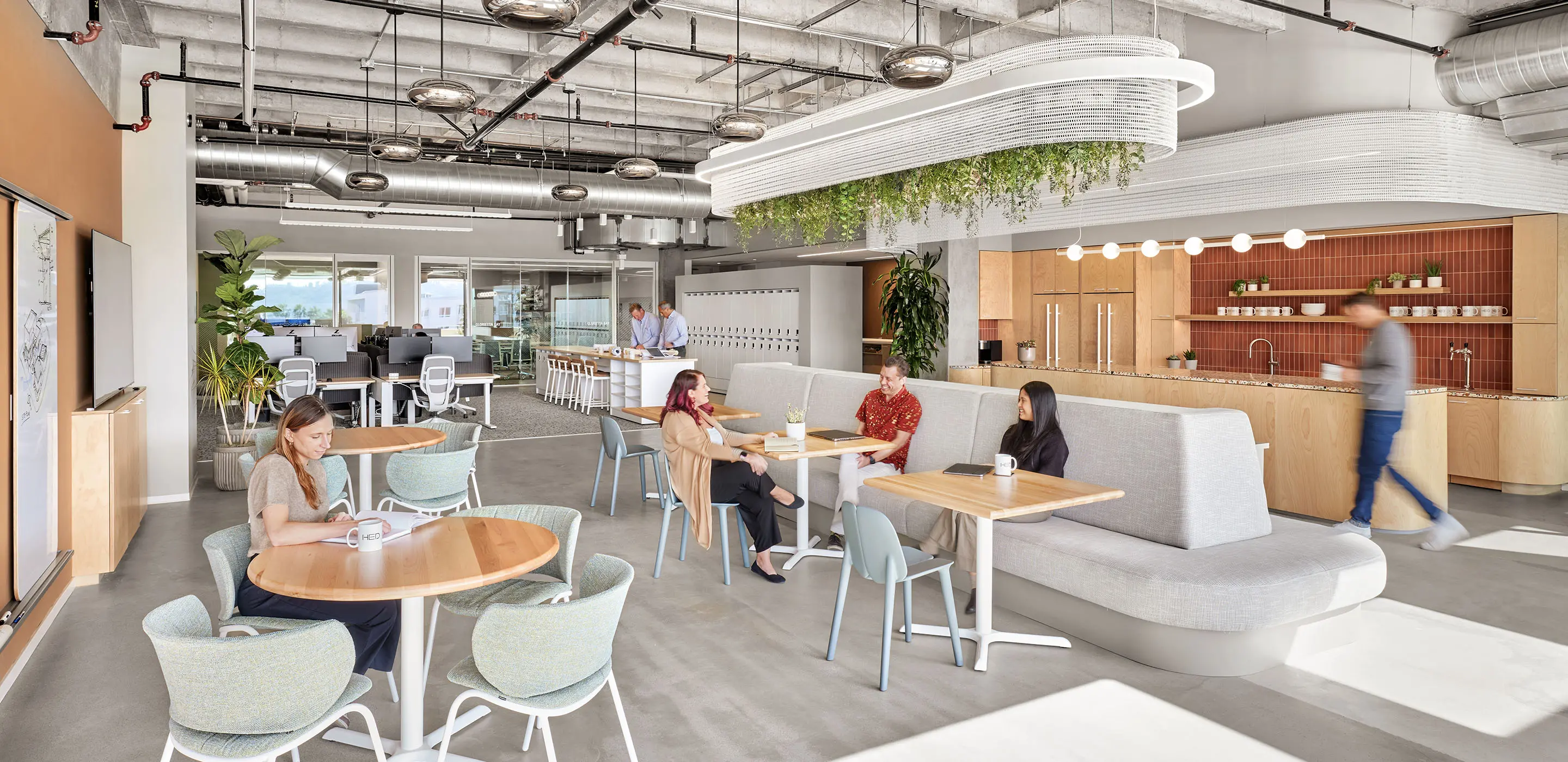 A group of young professionals congregating in a styling, open, airy office interior.