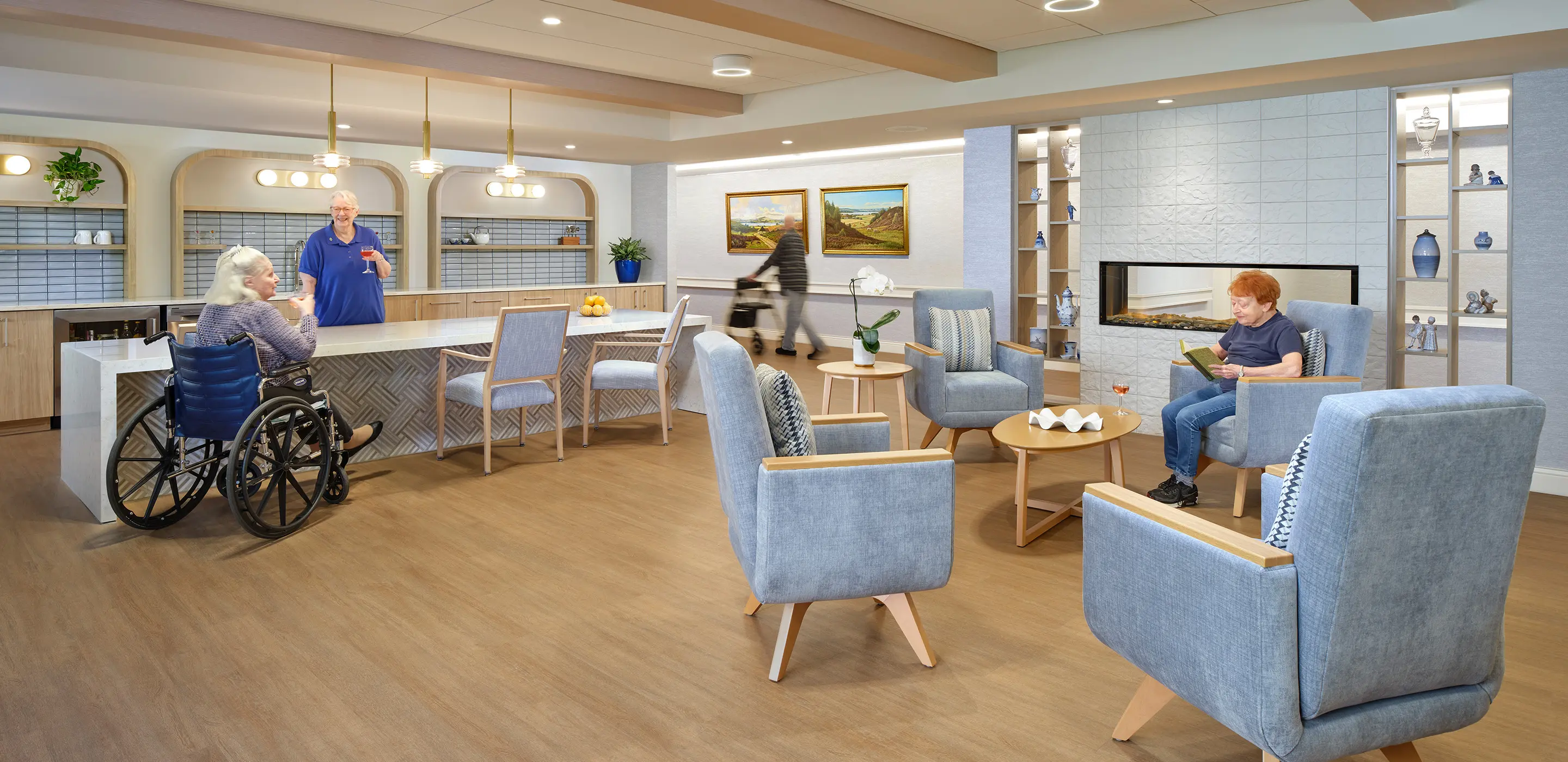 Cozy senior living lounge with residents socializing, reading, and relaxing near a modern fireplace and kitchen area.