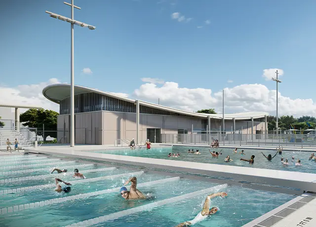 Modern outdoor swimming pool complex with swimmers and sunny sky.