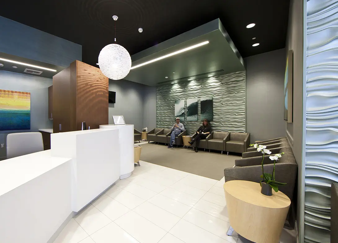 Modern waiting room with stylish decor, comfortable seating, and a reception desk.