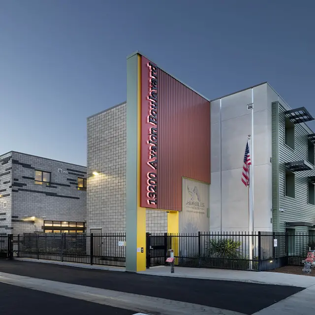 Modern building with address 13200 Avalon Boulevard, featuring American flag and contemporary design elements.