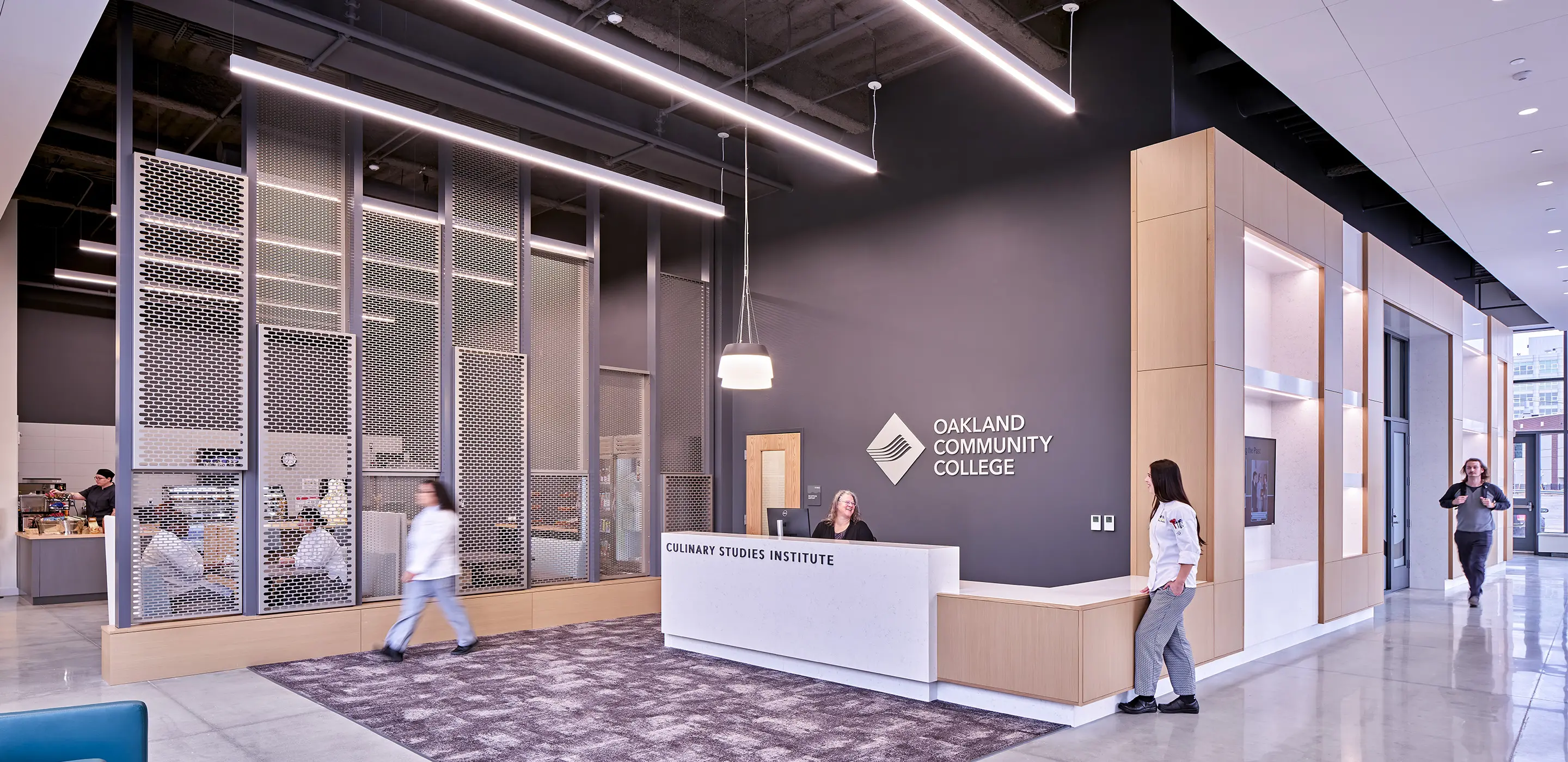 Reception area of Oakland Community College Culinary Studies Institute with modern design and people interacting.