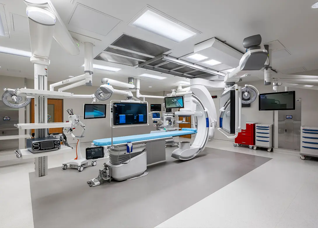 Modern hospital operating room with advanced medical equipment and monitors, featuring a sterile, high-tech environment.