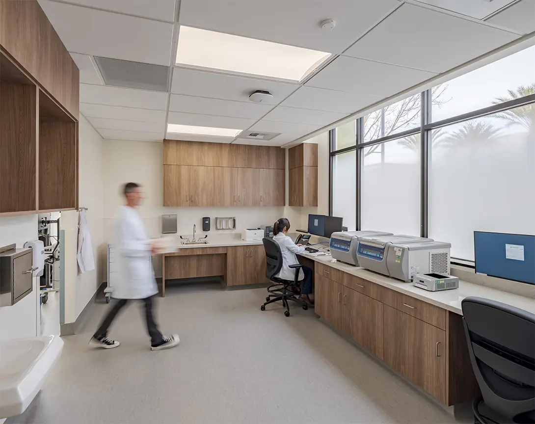 Modern laboratory with researchers in lab coats, advanced equipment, and natural lighting from large windows.