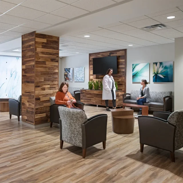 Modern medical office waiting area with wooden decor, comfortable seating, and artwork on the walls.