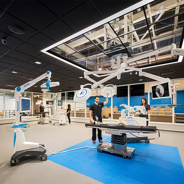 Modern operating room with advanced robotic surgery equipment and medical professionals in training.