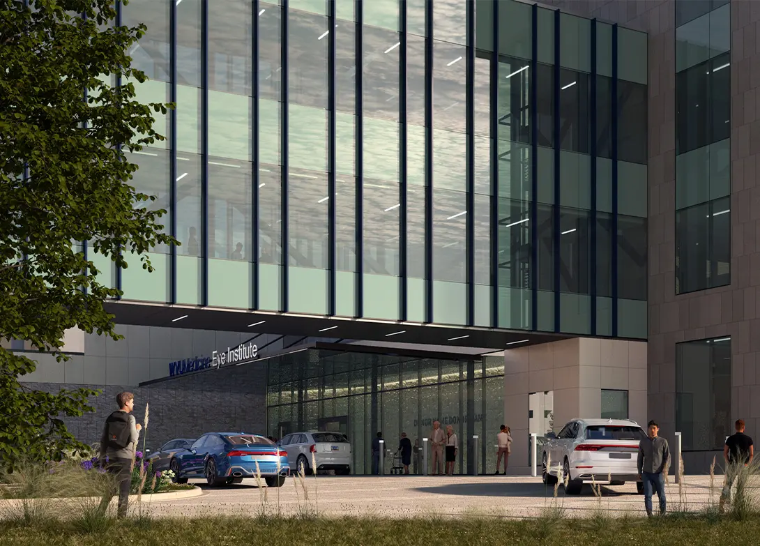 Modern glass-fronted building with cars and people outside, labeled Eye Institute.
