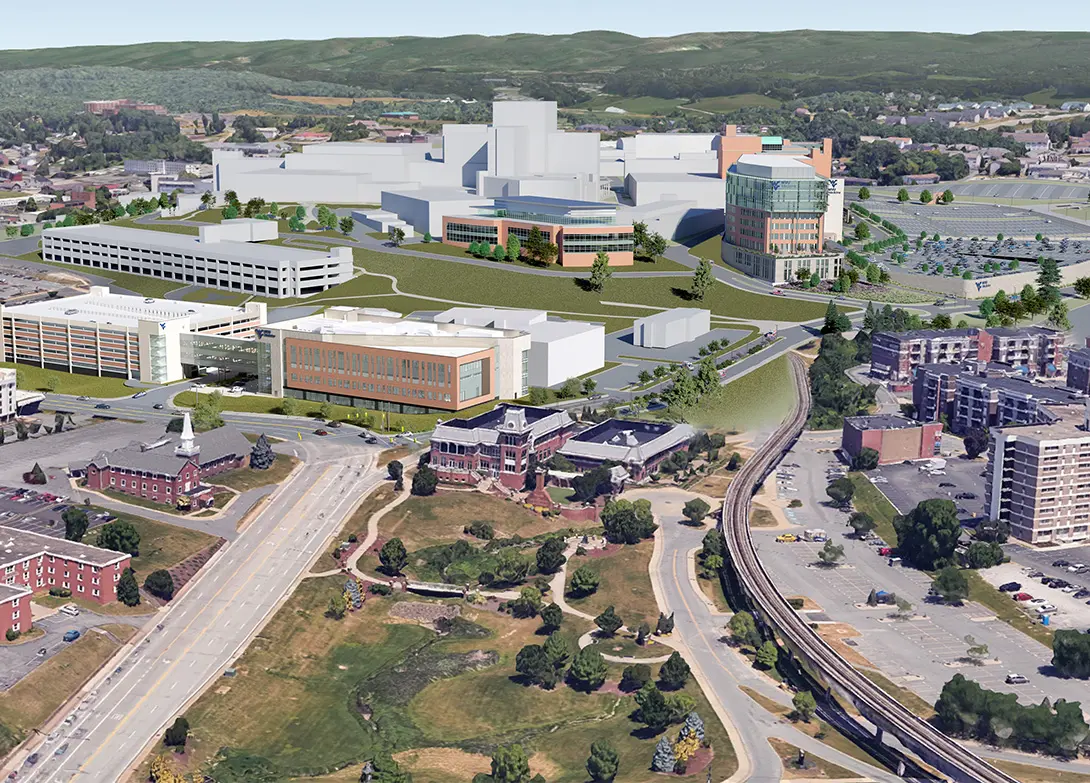 Aerial view of a modern hospital campus with parking and surrounding greenery.
