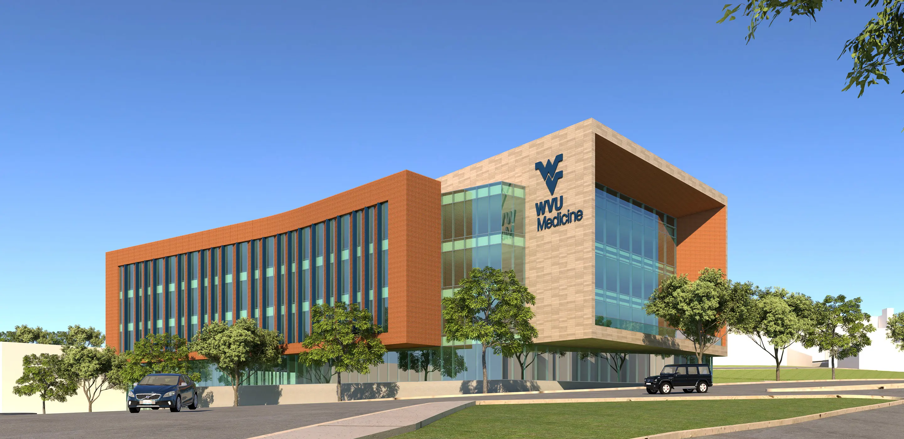Modern WVU Medicine building with glass facade and trees under a clear blue sky.