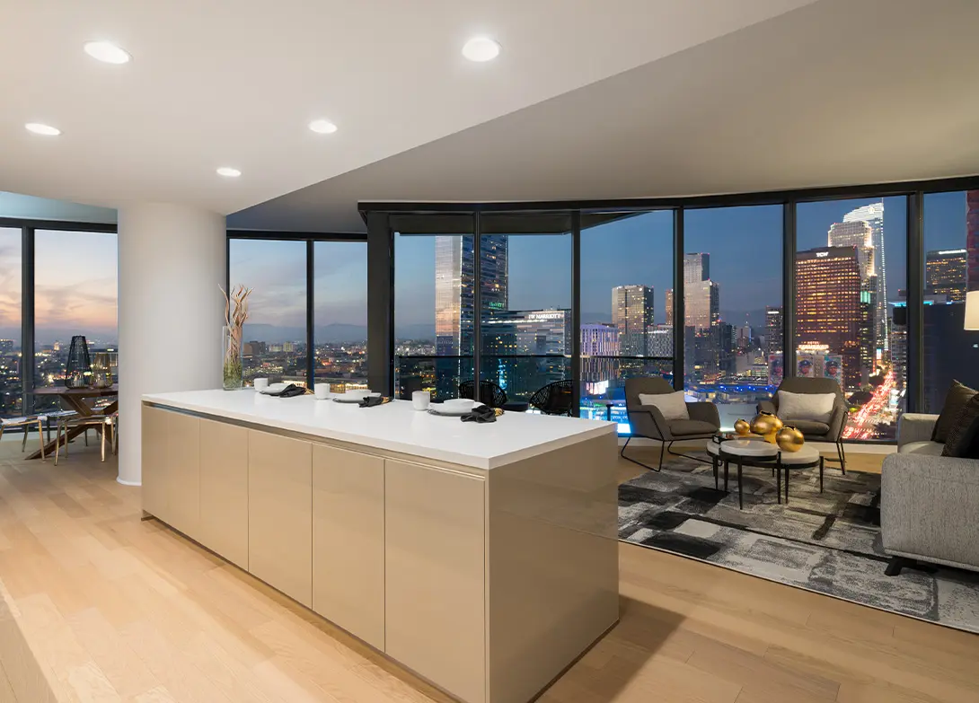 Modern apartment interior with city skyline view at night, featuring sleek kitchen and cozy living area.