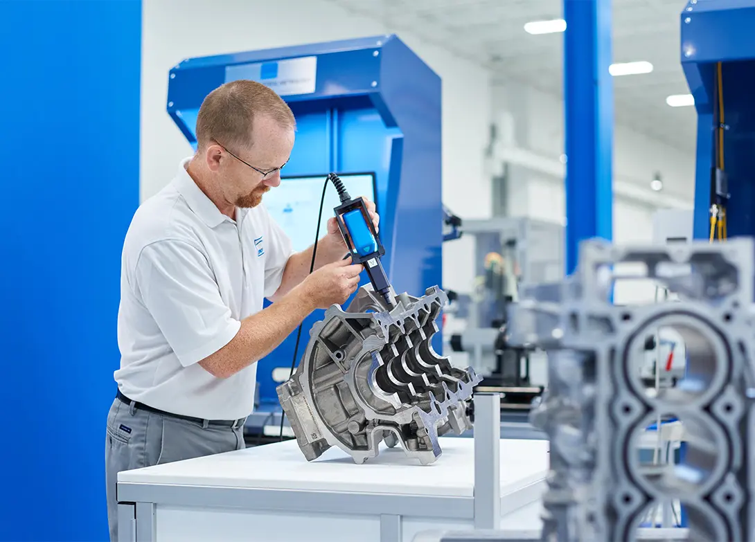 Technician inspecting an engine block in a high-tech automotive lab.