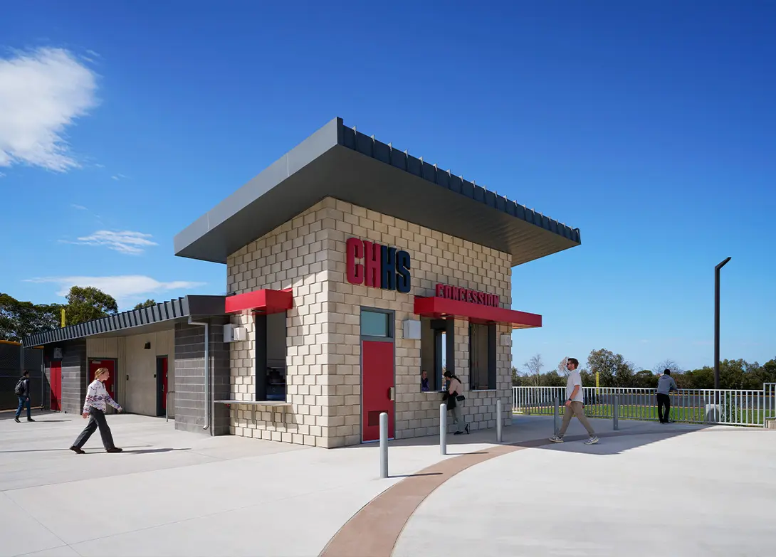 Modern concession stand at CHHS with clear blue sky, people walking nearby.