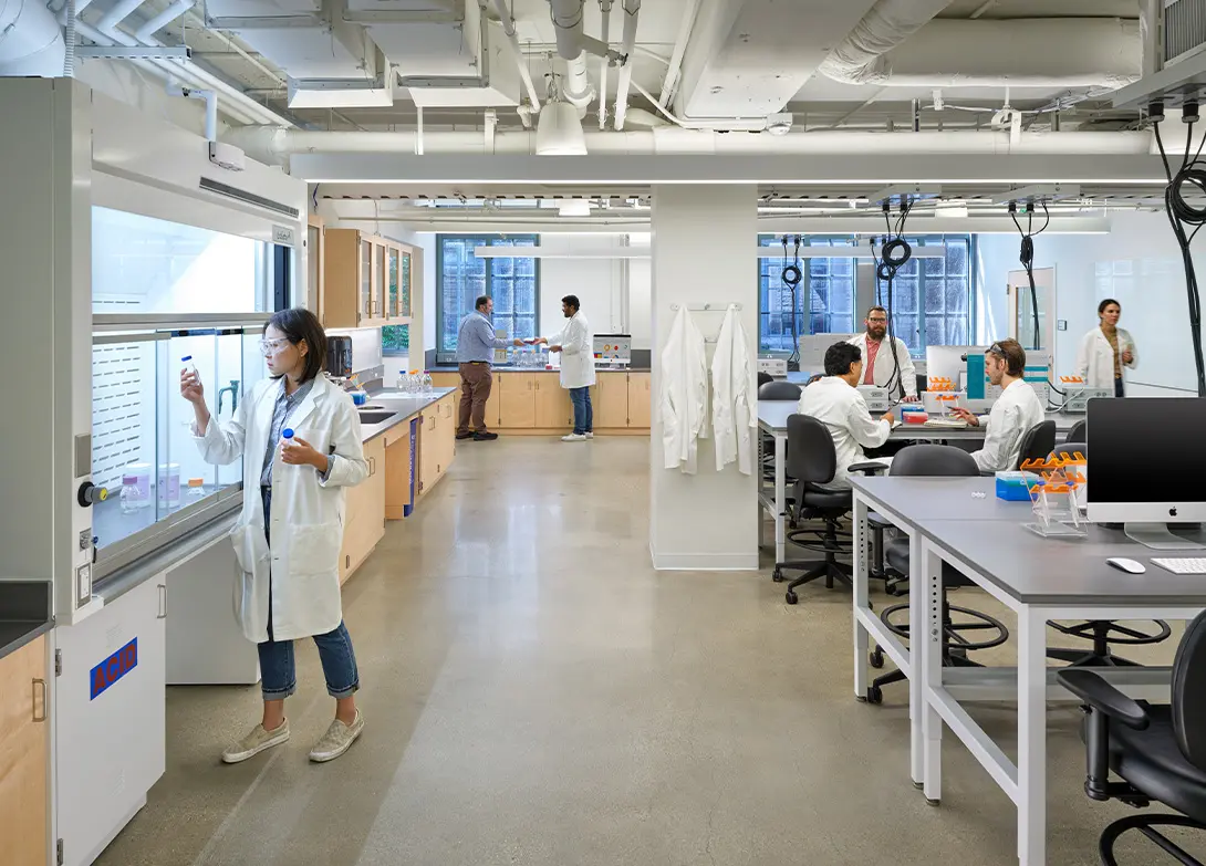 Scientists in a modern laboratory working on research and experiments, wearing white lab coats.