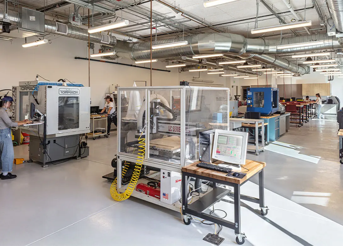 Modern manufacturing lab with advanced machinery and technicians working on high-tech equipment.