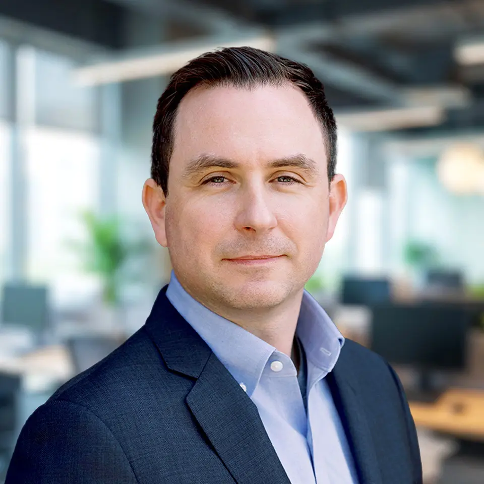 Professional man in a suit in a modern office setting, promoting business or corporate concepts.