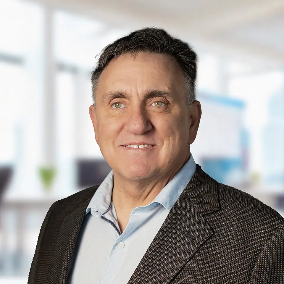 Business professional in suit smiling in bright office setting.