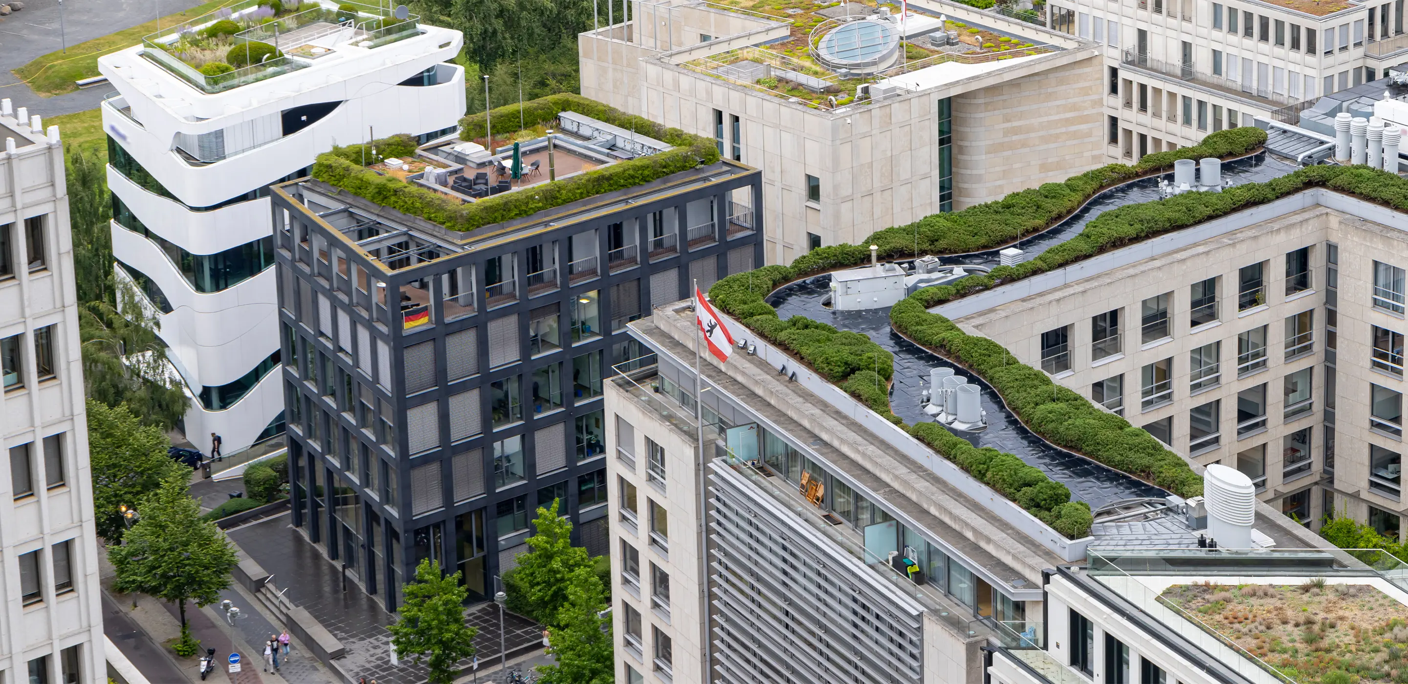Aerial view of eco-friendly buildings with green rooftops in a modern urban cityscape, enhancing sustainability.