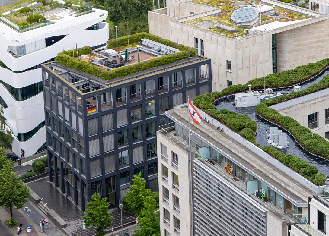 Aerial view of modern buildings with green rooftops in an urban setting, showcasing sustainable architecture.