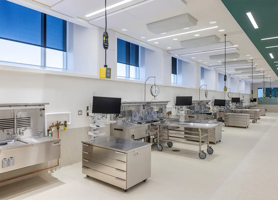 Modern laboratory with stainless steel workstations, computers, and medical equipment in a bright and clean room.