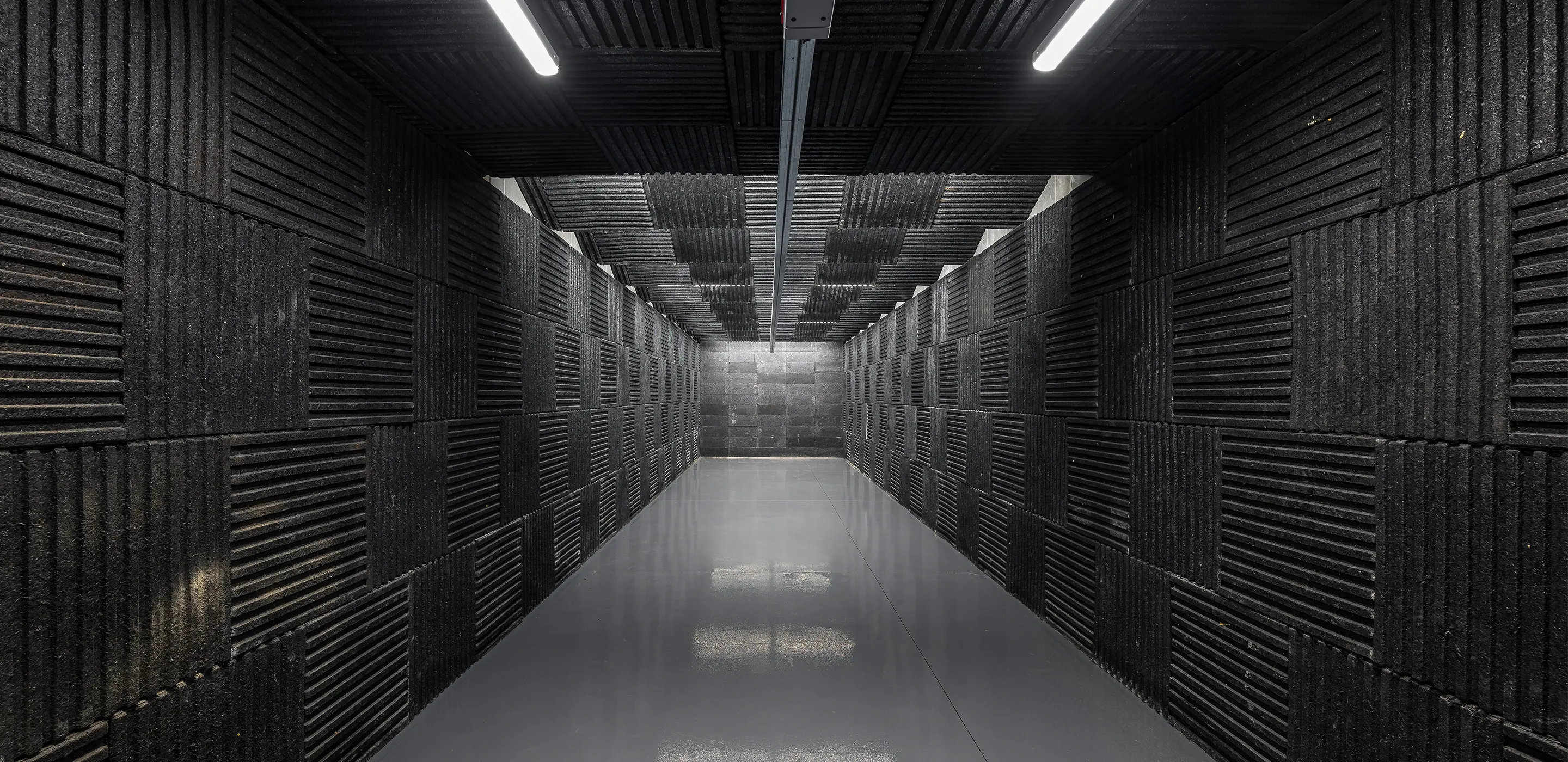 Acoustic foam-lined hallway with modern lighting for noise absorption and soundproofing purposes.