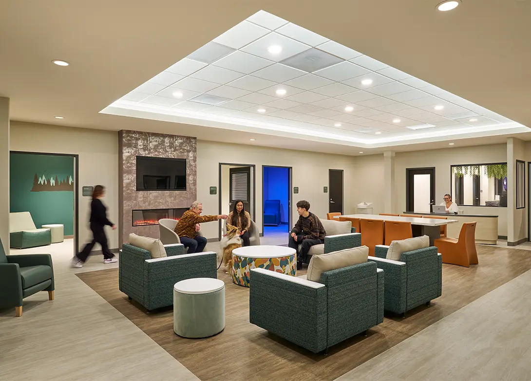 Modern community lounge with people, seating, and a fireplace, creating a welcoming atmosphere.